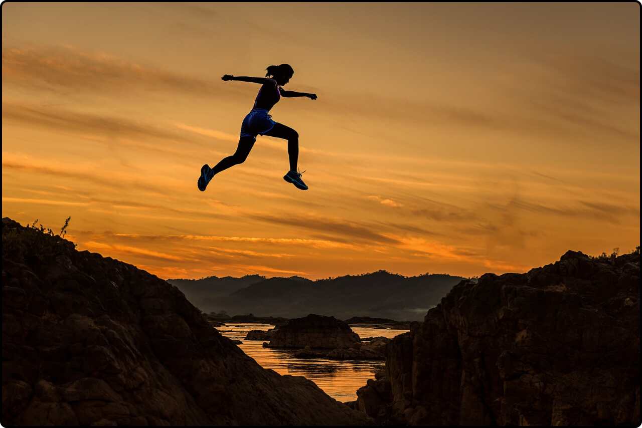 Athletic girl mid-air while performing a jump.